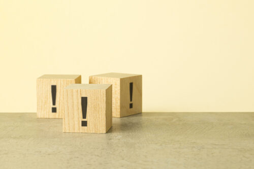 exclamation marks are written on wooden blocks. Blocks are located on a red background