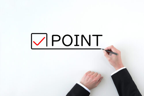 Hand of a businessman drawing check marks and point words